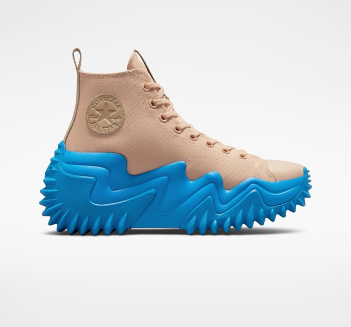 View of tan and blue Converse shoe.